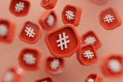 Red 3D icons with white hashtag symbols float against a soft, peach-colored background.