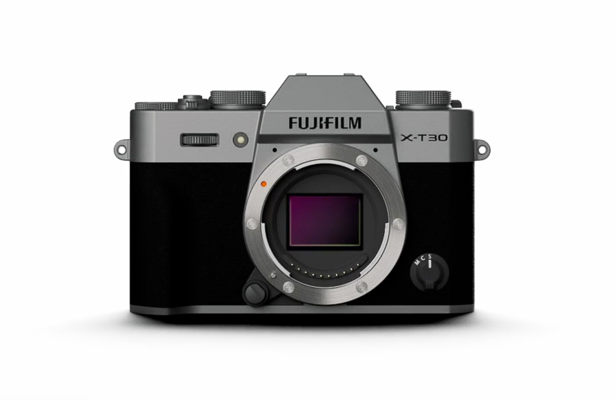 Front view of a Fujifilm X-T30 mirrorless camera showing the lens mount and various control dials on the top.