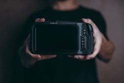 Person holding a blackmagic design video assist monitor/recorder.
