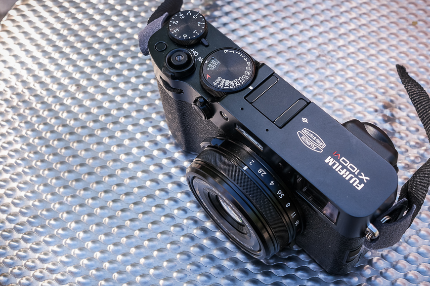 A fujifilm mirrorless camera placed on a textured blue surface.