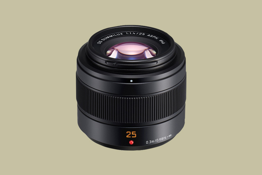 A black camera lens with "25" marked in orange, labeled as a Leica DG Summilux 25mm f/1.4 ASPH, shown against a plain light brown background.