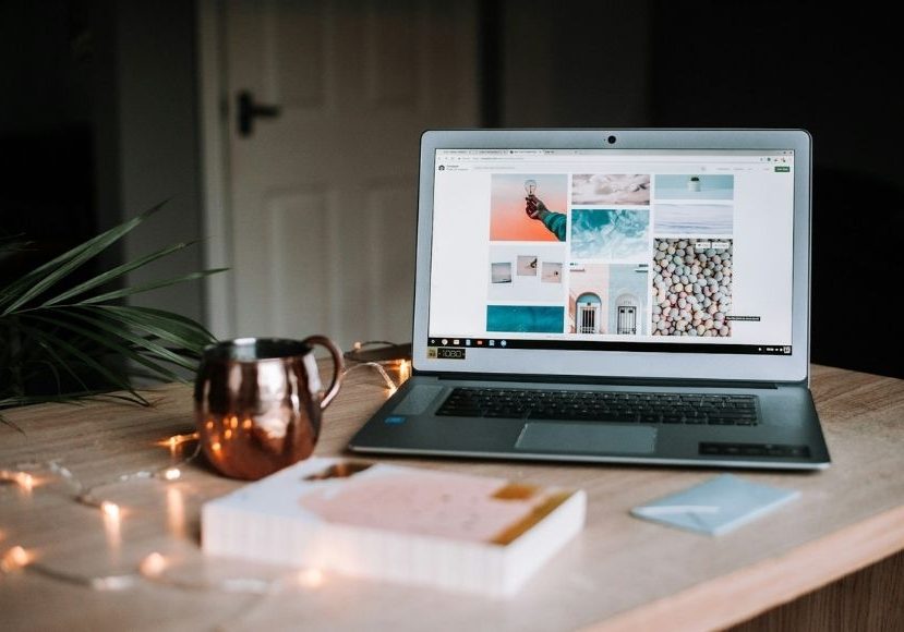 Laptop on a wooden table displaying a mood board, accompanied by a notepad, pen, a mug, and string lights. Laptop on a wooden table displaying a mood board, accompanied by a notepad, pen, a mug, and string lights.