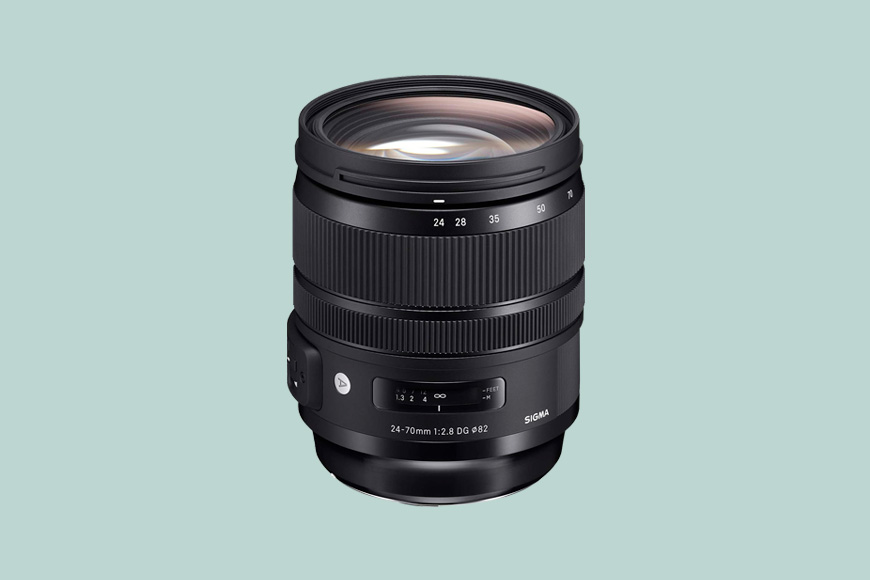 A black Sigma 24-70mm f/2.8 DG OS HSM lens with zoom and focus rings, set against a light green background.