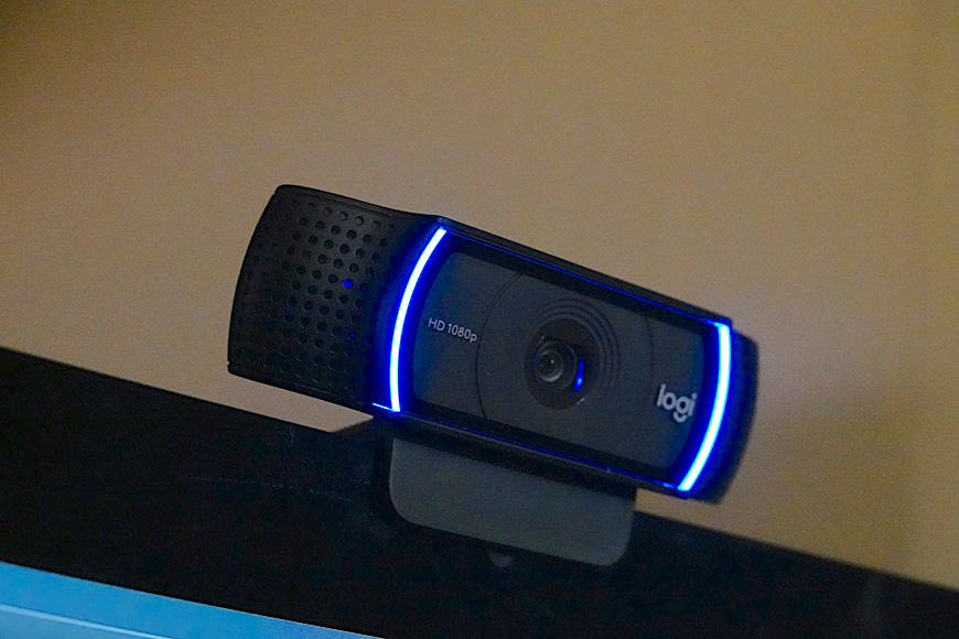 A webcam with blue LED lights is mounted on top of a monitor.